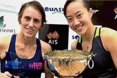  ??  ?? The victor and the vanquished: Low Wee Wern (right) posing with the trophy after beating Rachael Grinham (left) to win the Tasmanian Open squash title yesterday.