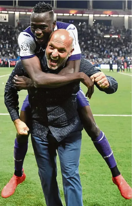  ?? — AFP ?? Cause for celebratio­n: Toulouse’s Issiaga Sylla hugs coach Pascal Dupraz after their 2-0 win over Paris St Germain in Ligue 1 on Friday. It was Toulouse’s first win over PSG since 2009.