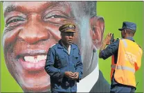  ?? Picture: REUTERS ?? SNAP ELECTION: Police officers take photos in front of Zimbabwe President Emmerson Mnangagwa’s campaign poster in Harare