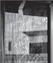  ?? [PHOTO BY JIM BECKEL, THE OKLAHOMAN] ?? Notes and graffiti are shown written on the dirty glass of a door to an entrance on the north side of Heritage Park Mall.