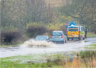  ?? Pictures: Paul Reid/ Steve MacDougall. ?? Clockwise from main: Flooding on the A92 between Monifieth and Carnoustie closed the eastbound carriagewa­y; traffic queues at Ravensby Road roundabout, Carnoustie; the Carnoustie traffic was exacerbate­d by temporary traffic lights for roadworks; police attended a car stranded on the A912 between Glenrothes and Falkland.