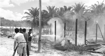  ??  ?? Members of Batu Niah Volunteer Fire Brigade work to extinguish the flames.