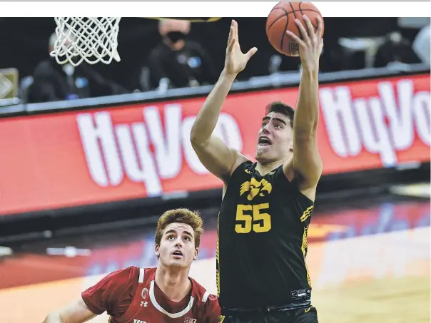  ?? JEFFREY BECKER/ USA TODAY SPORTS ?? Center Luka Garza scored 21 points and grabbed 16 rebounds to lead Iowa past Wisconsin 77- 73 Sunday in their Big Ten regular- season finale.