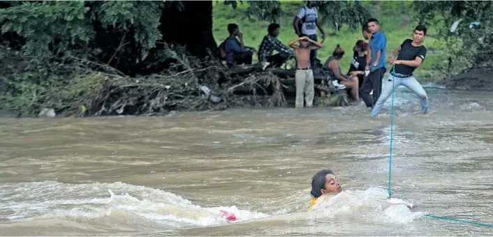  ??  ?? Diese Honduraner­in kämpft im Grenzfluss Goascorán, der ihr Heimatland von El Salvador trennt, um ihr Leben. Ihr Ziel, genauso wie für tausende andere: die USA.