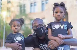  ??  ?? Christophe­r Wall attends the rally with his daughters Imani, 2, and Nia, 5. The protest drew more than 75 attendees.