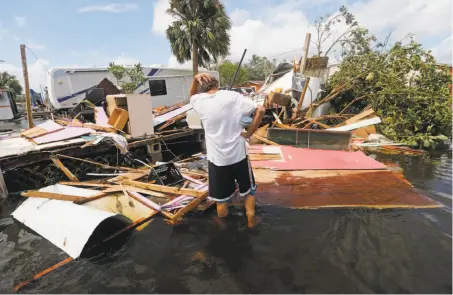  ?? Photos by Gerald Herbert / Associated Press ?? Larry Dimas examines the wreckage of his trailer, which he rents to tenants, in Immokalee, Fla. The tenants evacuated before the storm struck, and no one was inside when it was destroyed by Irma. Immokalee is about 50 miles northeast of Naples.