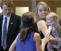  ?? AP FILE ?? ‘DEEPLY MISSED’: Saoirse Kennedy Hill, right, holds a relative’s baby before a ceremony for naming a Navy ship after Robert F. Kennedy at the John F. Kennedy Presidenti­al Library in September 2016. At left is U.S. Rep. Joseph P. Kennedy III.