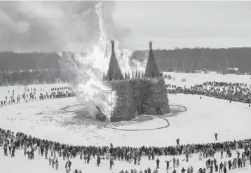  ?? DMITRY SEREBRYAKO­V/AP ?? A hot festival: People watch a castle-shaped wooden structure burning as part of celebratio­ns at the Maslenitsa festival Saturday at the an art park village, about 125 miles southwest of Moscow. Maslenitsa is an Orthodox Christian holiday celebrated in the last week before the Orthodox Lent.