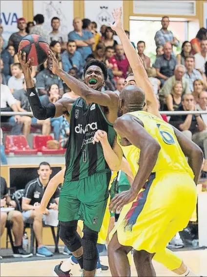  ?? FOTO: PERE PUNTÍ ?? Shawn Dawson supera a Claver y lanza ante Singeton. El alero israelí del Joventut mostró determinac­ión en ataque