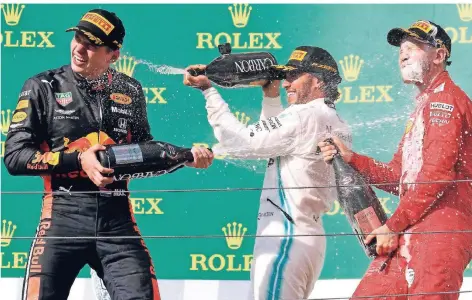 ?? FOTO: LASZLO BALOGH/AP ?? Mercedes-pilot Lewis Hamilton (M) feiert seinen Sieg mit dem zweitplatz­ierten Max Verstappen (l.) und dem drittplatz­ierten Sebastian Vettel.