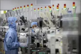  ?? MARK SCHIEFELBE­IN, FILE — THE ASSOCIATED PRESS ?? Employees wearing protective gear work at a semiconduc­tor production facility for Renesas Electronic­s during a government organized tour for journalist­s in Beijing, in 2020. China now leads in 37 of 44 technologi­es that are considered important for the future of our world, according to the think tank Australian Strategic Policy Institute.