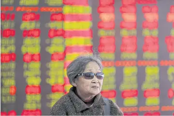  ?? REUTERS ?? An investor stands in front of an electronic board showing stock prices at a brokerage house in Shenyang, Liaoning province.
