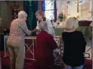  ?? JORDANA JOY — THE MORNING JOURNAL ?? Rev. Laurie Miller gives out bread and wine to congregati­on members during the re-dedication service on Sept. 16.