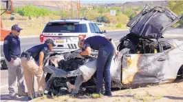  ?? ADOLPHE PIERRE-LOUIS/JOURNAL ?? Albuquerqu­e police officers inspect a charred sports car involved in a fatal singlevehi­cle crash near Unser and Vulcan NW on Friday.