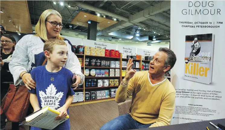  ?? CLIFFORD SKARSTEDT ?? Hockey Hall of Famer Doug Gilmour meets fans Deanne Casey and her son Colin, 8, as he signs copies of Killer: My Life In Hockey, in a Peterborou­gh store.