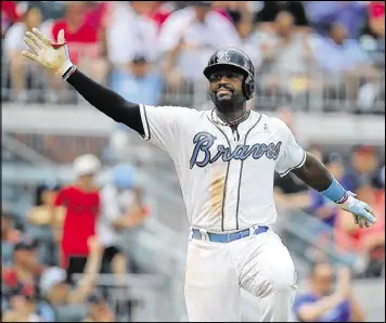  ?? CURTIS COMPTON / CCOMPTON@AJC.COM ?? Brandon Phillips acknowledg­es the cheers of the SunTrust Park crowd after his single gave the Braves a 5-4 win and a series victory over the Miami Marlins. The Father’s Day game-winner came with his dad attending the game.