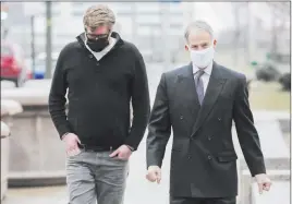  ?? Joshua A. Bickel The Associated Press ?? Dustin Thompson, left, arrives with his lawyer, Sam Shamansky, to turn himself in Monday at the Joseph P. Kinneary U.S. District Courthouse in Columbus, Ohio.