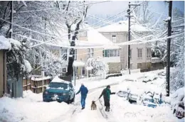  ?? ELIAS FUNEZ THE UNION VIA AP ?? Residents navigate heavy snow in Nevada County, Calif., on Monday. The winter storm shattered records for snowfall and low temperatur­es across the West.