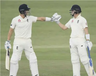  ??  ?? 0 England batsman Joe Denly celebrates with Ollie Pope, right, after reaching his century.