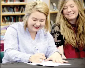  ?? LYNN KUTTER ENTERPRISE-LEADER ?? Christy Westlin, right, watches as her daughter, Dixie Miller, signs a letter of intent with Hutchinson Community College in Hutchinson, Kan.