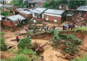  ?? ?? People gather in an area damaged in floods in Blantyre, Malawi, on 14 March