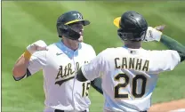  ?? TONY AVELAR — THE ASSOCIATED PRESS ?? The Oakland Athletics’ Seth Brown (15) is congratula­ted by teammate Mark Canha (20) after hitting a two-run home run against the Tampa Bay Rays during the first inning Saturday in Oakland.