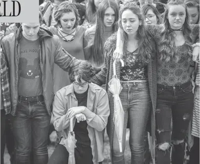  ?? BENJAMIN ZACK / STANDARD-EXAMINER VIA AP ?? Student protesters at Weber High School in Pleasant View, Utah, observe a moment of silence as the names of the victims from the Marjory Stoneman Douglas High School shooting are read aloud on Wednesday.