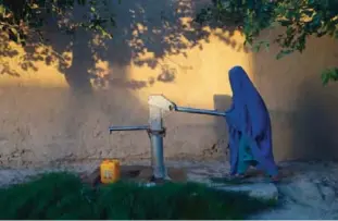  ??  ?? BALKH PROVINCE: An Afghan woman collects water from a hand pump in Mazar-i-Sharif in Ghazni province. —AFP