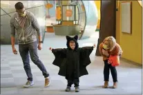  ?? RICK BOWMER - THE ASSOCIATED PRESS ?? Grayson Martin, 3, poses in his costume as his parents Rachelle and Patrick Martin, look on, during a visit to Discovery Gateway Children’s Museum on Thursday, in Salt Lake City. Coronaviru­s cases in the U.S. are on the decline, and trick-or-treaters can feel safer collecting candy.