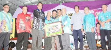  ??  ?? Paulus (fourth right) presents a memento to Dr Abdul Rahman, witnessed by Antonio (second left), Peter, Denny (sixth left), Sufian (third right) and others.