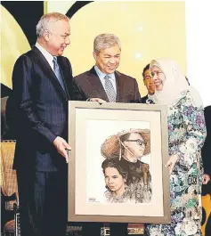  ??  ?? Sultan Nazrin Shah (left) presenting a memento to Tun Rahah at the Utusan Business Awards 2015 at the Kuala Lumpur Convention Centre as Zahid looks on. — Bernama photo