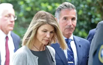  ?? STuART cAHILL / HeRALd sTAFF FILe ?? NOW BOARDING: Actress Lori Loughlin and her husband, Mossimo Giannulli, are seen outside court in the Seaport after a hearing in their ‘Varsity Blues’ fraud case.