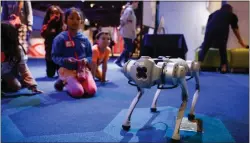  ?? ?? Unitree Dog, a robotic dog, interacts with children during National AI Literacy Day at Tech Interactiv­e in San Jose on April 19.