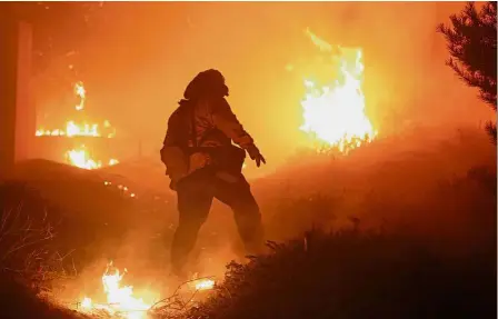  ?? — Reuters ?? Searing heat: A firefighte­r stomping out small embers on a ranch in the San Fernando Valley north of Los Angeles.