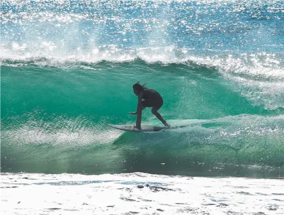  ??  ?? Surfers are enjoying good swell at Gold Coast breaks, including this boardrider at Burleigh Heads yesterday, Picture: MIKE BATTERHAM