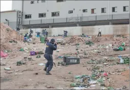  ??  ?? ESCENAS. Un negocio atacado. Balas de goma contra saqueadore­s.