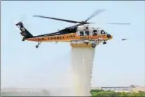  ?? PHOTO BY TRENT BELL ?? In this photo from Fire Aviation, a Los Angeles County Fire Department Sikorsky S-70 Firehawk helicopter demonstrat­es a water drop during a 2013 airshow. The company last week delivered two S-70i Black Hawk aircraft to the department.