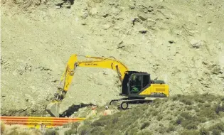  ?? PHOTO: ALEXIA JOHNSTON ?? Digging in . . . An excavator works to clear debris from the base of the slip that loomed over State Highway 8 in July after material again moved following heavy and persistent rain earlier this month.