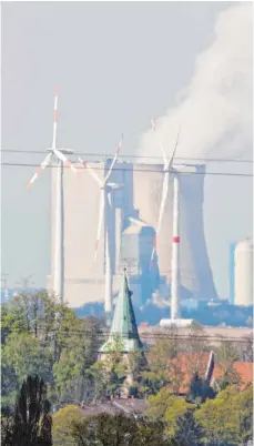  ?? FOTO: JULIAN STRATENSCH­ULTE ?? Windräder vor einem Kohlekraft­werk in Niedersach­sen: Die deutschen Energiekon­zerne machen weniger Gewinn.