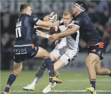  ??  ?? Ulster’s Will Addison attempts to find a way past Tom Brown and Stuart Mcinally of Edinburgh.