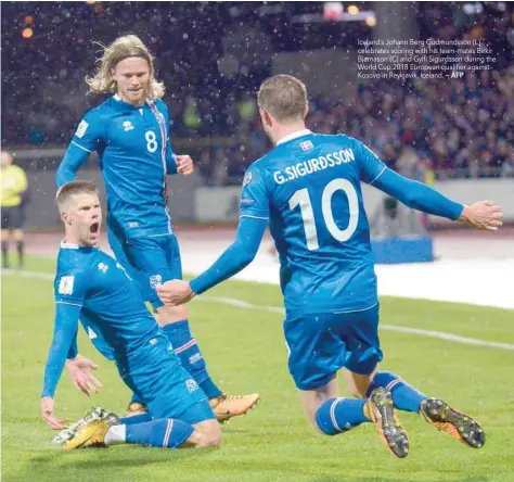  ?? — AFP ?? Iceland’s Johann Berg Gudmundsso­n (L) celebrates scoring with his team-mates Birkir Bjarnason (C) and Gylfi Sigurdsson during the World Cup 2018 European qualifier against Kosovo in Reykjavik, Iceland.