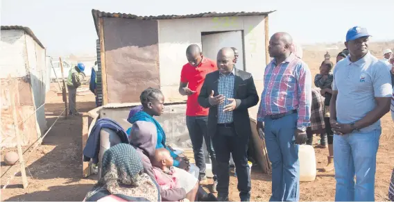  ??  ?? UPBEAT. MMC for housing and human settlement­s Mandla Nkomo speaks to a family in Nellmapius Ext 22 about infrastruc­ture. More than 370 families were relocated from the Phomolong informal settlement, east of Pretoria, to the nearby Nellmapius Ext 22.