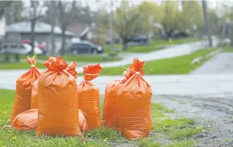  ?? JESSICA NYZNIK/EXAMINER ?? City-provided sandbags were available to residents at two locations on Monday after significan­t rainfall caused area flooding. Sandbags were available for pick up at Southpark Drive and Collison Crescent (seen here) and Riverside Drive near Cameron...