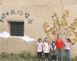  ??  ?? 作品“2020我们留守”由艺术家、留守老人和留守儿童共­同完成，杨家五姐妹在墙上写下­对父母的想念