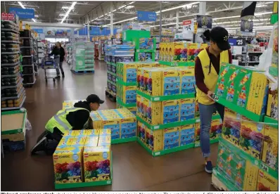  ?? (AP/John Locher) ?? Walmart employees stock shelves in a Las Vegas supercente­r in November. The retailer’s new fulfillmen­t service allows third-party vendors to use the Walmart delivery system and guarantees two-day delivery.
