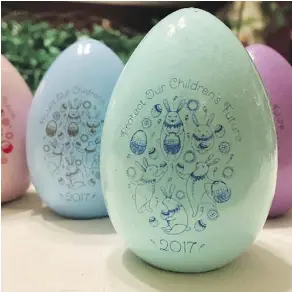  ??  ?? Natalie Rebetsky’s wooden Easter eggs are decorated with dancing bunnies and the slogan: “Protect Our Children’s Future 2017.”