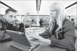  ?? David McNew Getty Images ?? THE STATE’S open enrollment period runs from Nov. 1 to Jan. 31. Above, Naama Pozniak, right, helps Edgar Loya compare Obamacare plans in Pasadena in 2013.