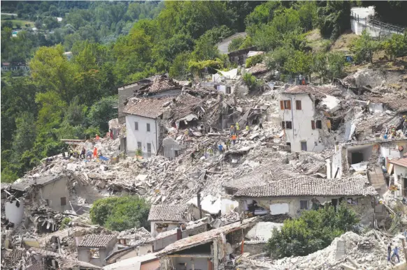  ?? AP PHOTO ?? Rescuers search through debris of collapsed houses following an earthquake in Pescara del Tronto, Italy, Wednesday.