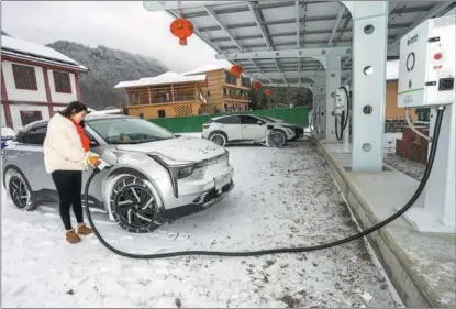  ?? WEN LIN / FOR CHINA DAILY ?? A villager uses newly establishe­d facilities to charge her electric car in Badong county, Hubei province, on Feb 2.