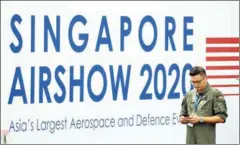  ?? AFP ?? A member of the Republic of Singapore Air Force stands next to a billboard during a media preview day ahead of the Singapore Airshow on Sunday.